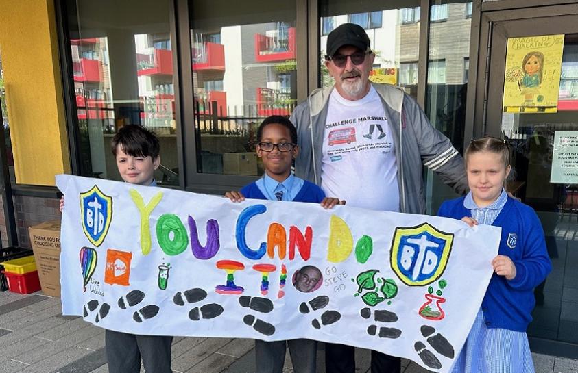 Barnet Council’s Steve Marshall is welcomed by children at Blessed Dominic Catholic School in Colindale during his charity walking challenge.